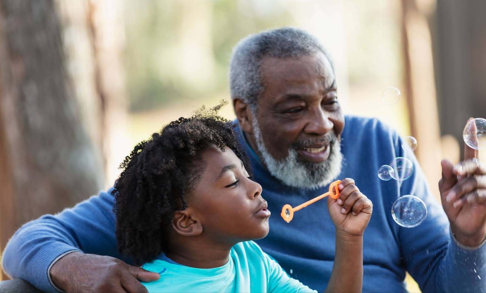 Senior man blowing bubbles with his grandson